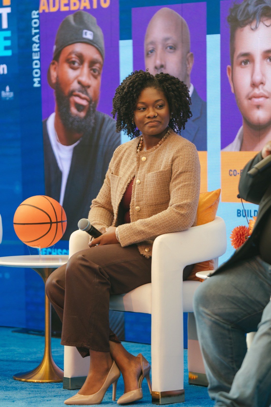 Ananda Nole seated on the CIAA panel stage in a camel tweed blazer